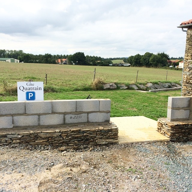Entre deux vacanciers, l'habillage du mur du parking continue.